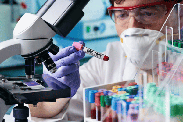 Laboratory testing with microscope and samples.